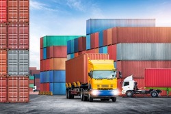 Transport of container truck at shipping depot dock yard background with stack colorful containers box, Logistics import export goods of freight carrier and global transportation industry concept