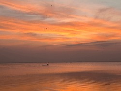 Fishing boat on the coast of puttalam Sri Lanka and beutiful orange yellow skies during a sunset