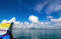 Travel with the boat go to the island and see the white clouds, blue sea and blue sky. 