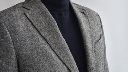Close up of mens fashionable grey tweed  blazer combined with black  sweater.  Selective focus.