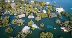 multiple houses half under water Aerial drone views high above Flooding caused by Climate Change