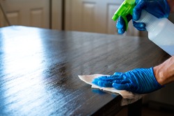 spraying down , wiping , and Cleaning Surfaces with Protective Gloves to disinfect and washing surfaces to protect against the Coronavirus or Covid-19 