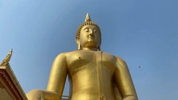 Golden Buddha statue at Wat Muang, Angthong province, Thailand, sacred place and blue sky is a bright beauty