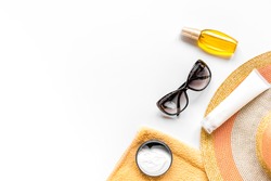 Sun protection composition with glasses and cream on white background top view mockup