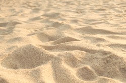 Texture of sand hills close up on the shore. Light sandy beach background.