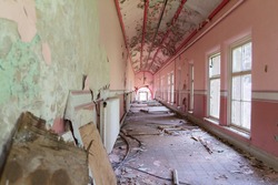 Abandoned corridor with decaying walls inside Whittingham Mental Asylum, the largest abandoned hospital in Europe