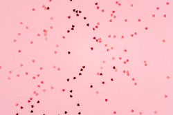 Pink background with glitter hearts for valentine's day. Beautiful wrapping paper or background for a postcard. Place for text, banner for website
