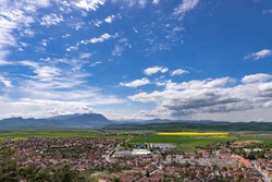 Spring view over Rasnov city, in Brasov county (Romania), with Piatra Craiului mountains in the background