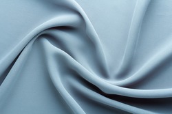 light blue fabric draped with curl folds, textile background