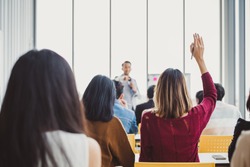 Business woman raising hand for asking speaker for question and answer concept in meeting room for seminar