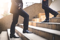 Close up legs of businessman walking stepping up stair in modern city, business growth, go up, success, grow up business concept