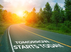 Tomorrow starts today, concept photo of asphalt road. Encouraging quote on road. Summer forest landscape with curved highway. Inspirational quote banner. Motivational card. Future planning concept
