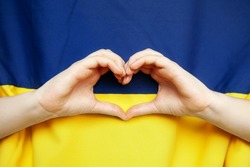 Hands in heart form on Ukrainian flag background, colors - yellow and blue. Independence day of Ukraine, Flag, Constitution day Education, Love Ukraine, Pray for Ukraine, no war, support concept