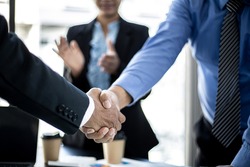 Close-up two business men holding hands, Two businessmen are agreeing on business together and shaking hands after a successful negotiation. Handshaking is a Western greeting or congratulation. 