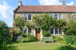 Exterior View and Garden Lawn of a Beautiful Old Rural English Cottage House
