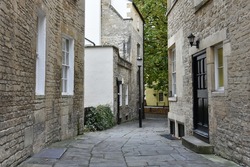 Narrow Dark Inner City Alley with Stone Paving, Old Buildings and a Vintage Lamppost 