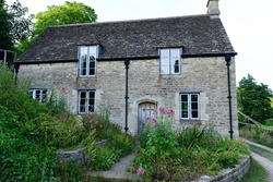 View of a Traditional Old Stone House on a Country Road in Rural England