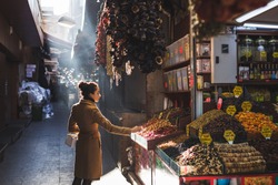 Woman chooses in the market nuts and dried fruit, the buyer tries goods at Grand Bazaar Istanbul
