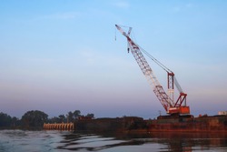 Crawler cranes used for rebuilding bridges  near the river in Thailand