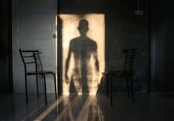 
The man's shadow stood in the door on the wall.
