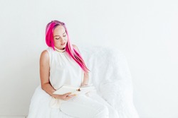 beautiful girl with pink hair reads the book education