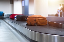 Suitcase or baggage on luggage conveyor belt in an arrivals lounge of airport terminal. Selective focus.