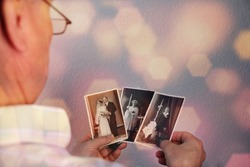 old man’s male hands hold old retro family photos in sepia color and looks at photographs of his and his sisters, made in 1963 - 1964, genealogy concept, ancestral memory, family 