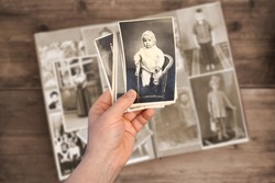 old man holds his old photos taken in 1960-1961, album with vintage monochrome photographs in sepia color, the concept of genealogy, memory of ancestors, family ties