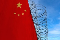 national flag of China on concrete wall, barbed wire fence, concept of prison, symbol of police state, territory border, totalitarian regime, restriction of rights and freedoms of citizens