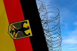 national flag of Germany on concrete wall, barbed wire fence, concept of prison, symbol of police state, territory border, totalitarian regime, restriction of rights and freedoms of citizens