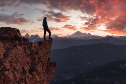Adventurous man is standing on top of the mountain and enjoying the beautiful view. Taken on top of Cheam Peak in Chilliwack, East of Vancouver, BC, Canada. Colorful Sunset Sky Art Render