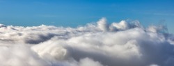 Aerial View from Above the White Puffy Clouds during a sunny day. Taken from Grouse Mountain, North Vancouver, British Columbia, Canada.