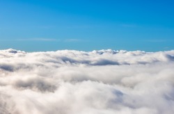 Aerial View from Above the White Puffy Clouds during a sunny day. Taken from Grouse Mountain, North Vancouver, British Columbia, Canada.