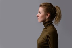 profile portrait of a casual pretty woman. Beautiful girl isolated on gray background