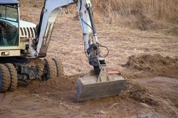 Earth moving tractor preparing place for future house foundation construction. Leveling soil for building new home