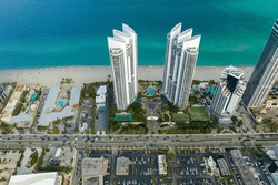 Sunny Isles Beach city with luxurious highrise hotels and condo buildings and busy ocean drive on Atlantic coast. American tourism infrastructure in southern Florida