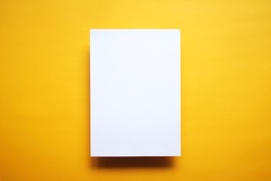 Empty white paper sheet isolated on yellow background