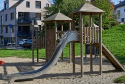 Children Playground with Modern Slide, Rope Net Bridge, Climbing Swings, Climbers. Empty Wooden Playground made of Eco Materials - Wooden Tree trunk. Colorful playground on yard in the park. Children