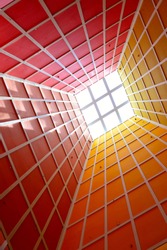 Abstract perspective of vertical lobby ceiling with skylight and strong geometry and symmetry and dramatic colors as background