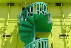 Green stone exterior spiral staircase on Singapore shophouse in historic Geylang with strong architectural detail, textures in perspective view 