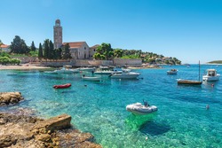 Turquoise water of Adriatic sea bay on Hvar island with franciscian monastery and boats in Dalmatia region, Croatia. Summer vacation destination