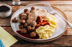 Swedish meatballs kottbullar, mashed potato, onion sauce and lingonberry sauce. Wooden background. Selective focus