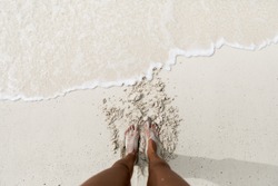 Feet on a white sand beach