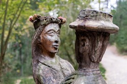 old wooden sculpture in the forest, a man and a woman dancing.Witch Hill park, Lithuania.