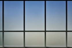 The glass window of building with white aluminum framework, Blue tone as background.