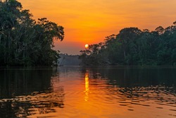 Lagoon sunset reflection in the Amazon river Rainforest. The Amazon river basin comprise the countries of Brazil, Bolivia, Colombia, Ecuador, Guyana, Suriname, Peru and Venezuela.