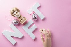 NFT (Non-Fungible token) and artificial arm on a pink background. Crypto art concept with antique bust and robotic arm. Technology selling unique collectibles and blockchain assets