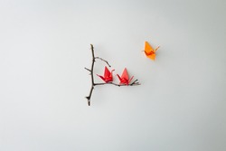 Three little origami birds on minimal falt lay branch tree