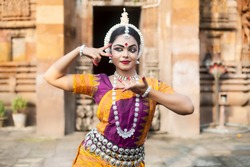 Beautiful Indian classical Odissi dancer Posing at Lingaraja Temple.Odissi or Orissi dance is a major ancient Indian classical dance form originated in the Hindu temples of Odisha.
