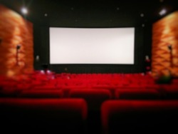 blurred empty cinema screen with red seats